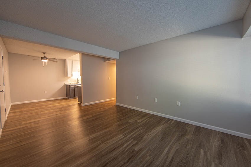an empty living room with a hard wood floor