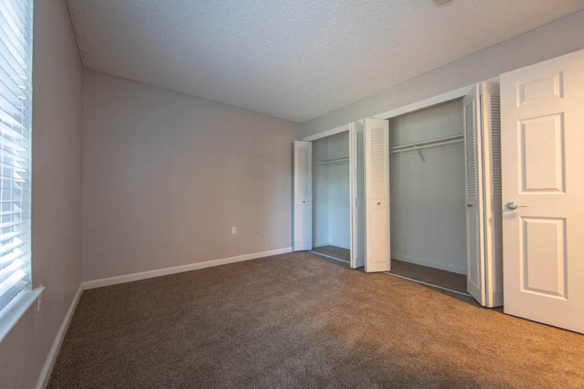 a bedroom with a closet and a door to a closet