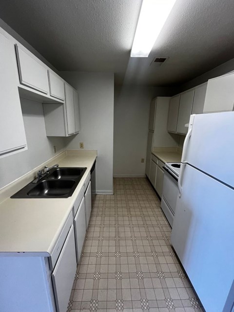 A kitchen with white appliances and white cabinets.