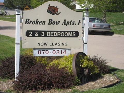 a sign for broken bow apples in front of a parking lot