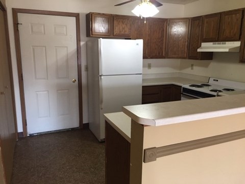 a kitchen with a white refrigerator and a door