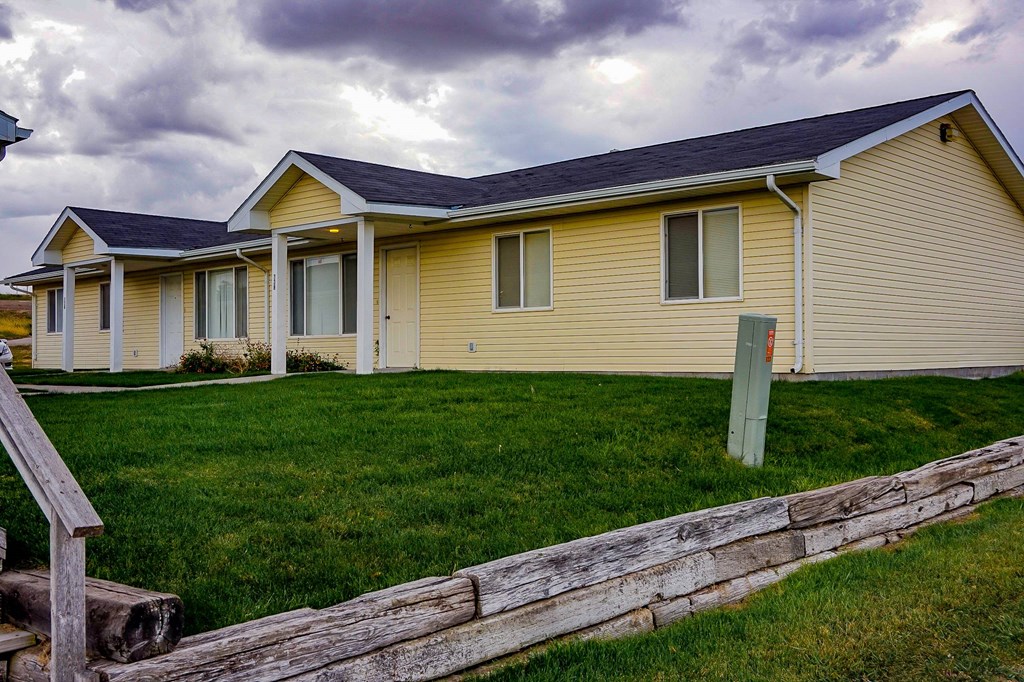 a yellow house with a wooden fence in front of it