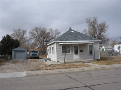 a small white house on the corner of a street