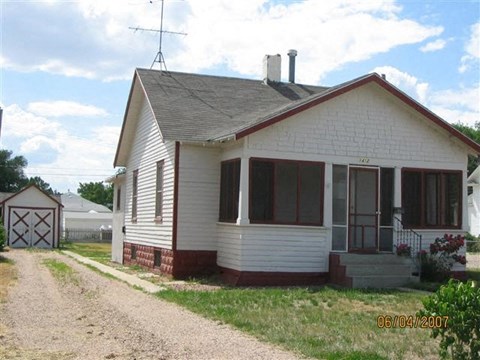 a white house with a dirt road in front of it
