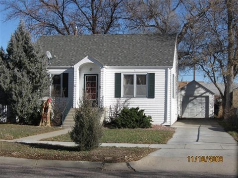 a white house with a gray roof and a sidewalk