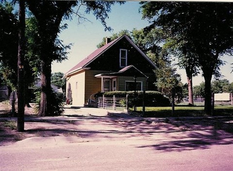 a house on the side of a street with trees