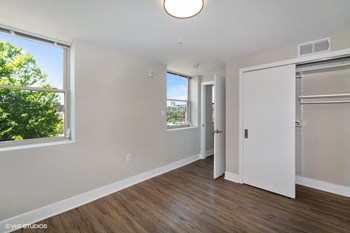 a bedroom with hardwood floors and white walls - Photo Gallery 13