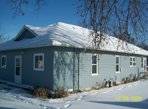 a blue house with snow on top of it
