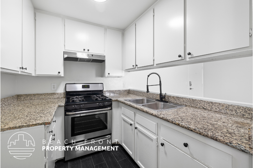 a kitchen with white cabinets and granite counter tops
