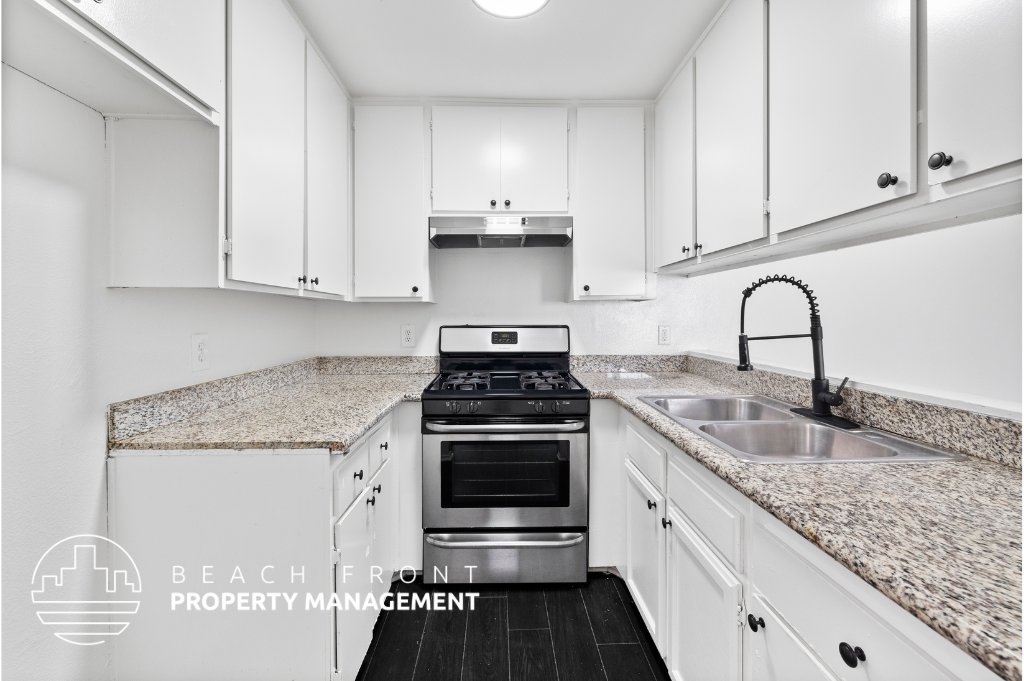 a kitchen with white cabinets and granite counter tops
