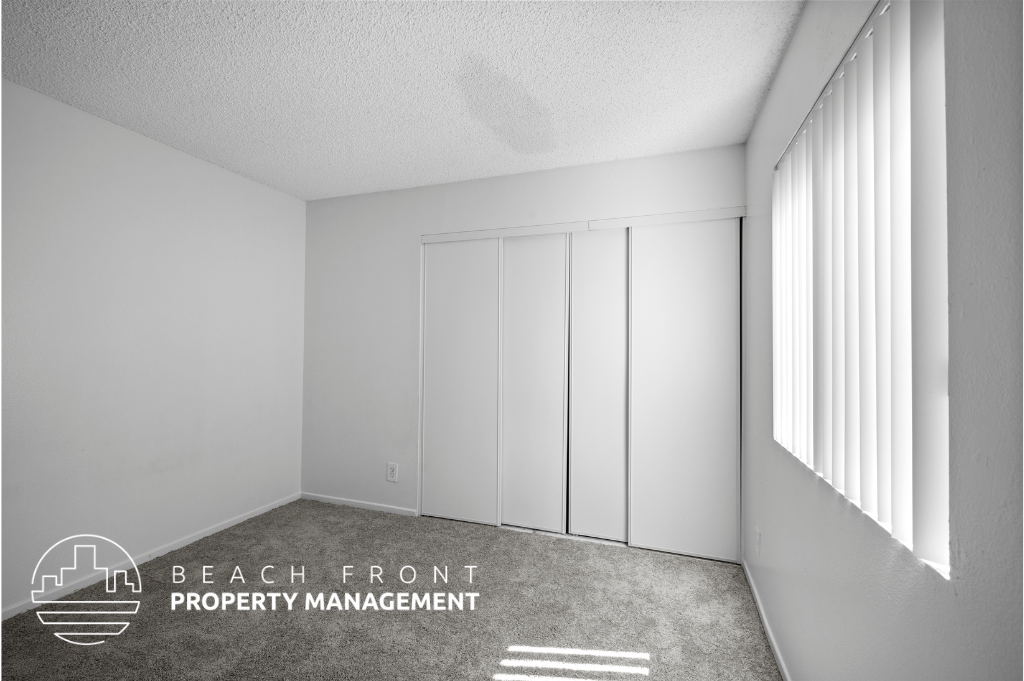 a bedroom with white closets and a carpeted floor