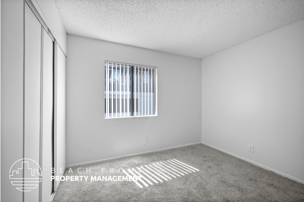 a room with a window and a rug on the floor