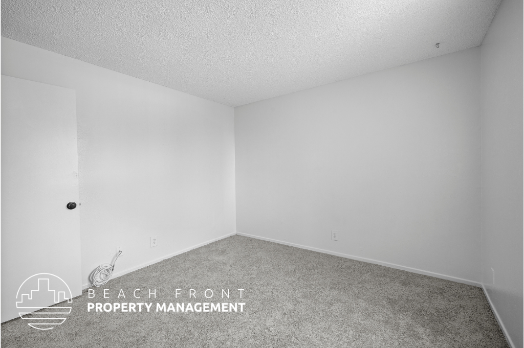 a bedroom with white walls and carpet and a white door