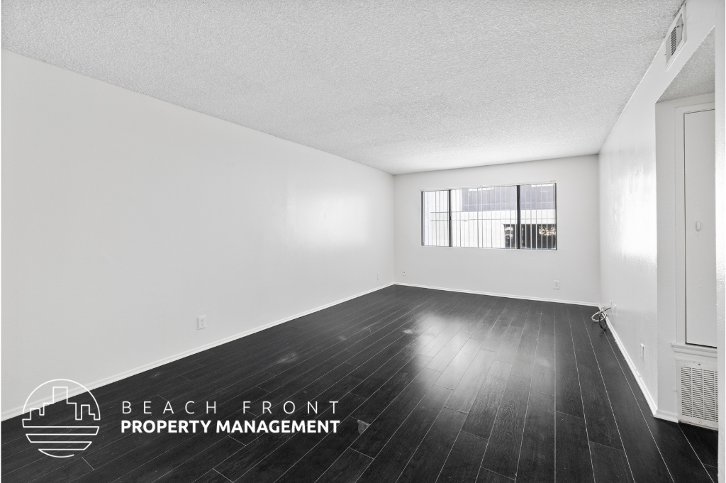 an empty room with wood floors and a window