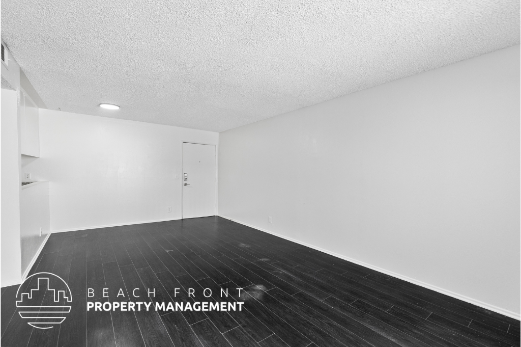a room with wood floors and white walls and a white door