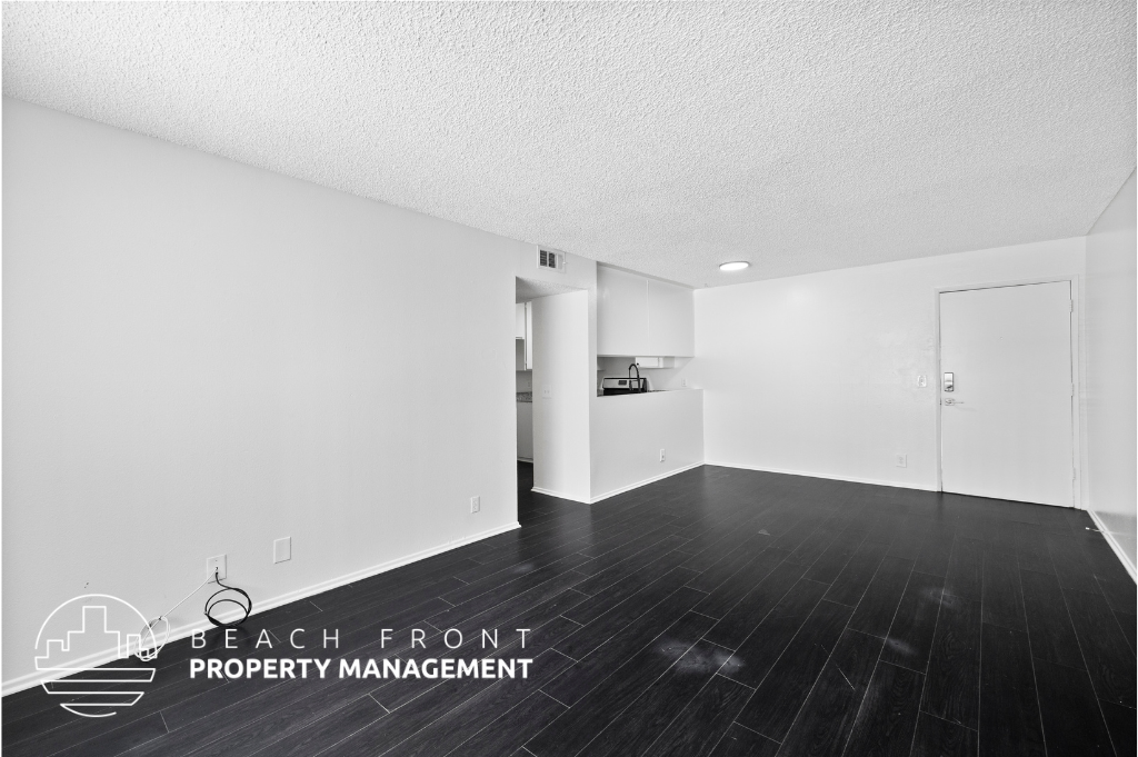 a white and black living room and kitchen with wood flooring