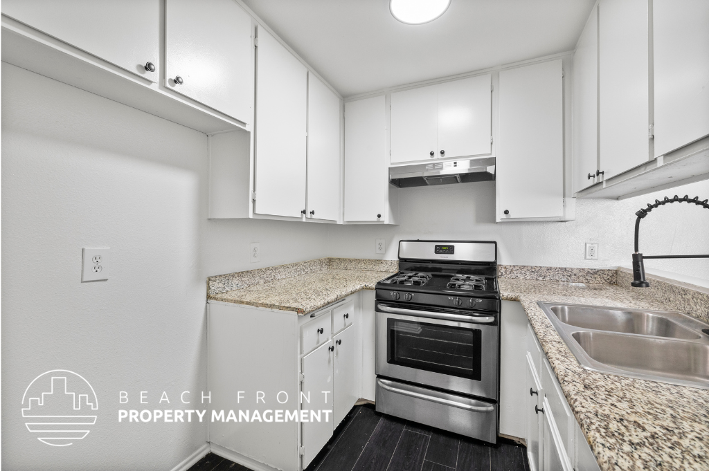 a kitchen with white cabinets and granite counter tops and a stove top oven
