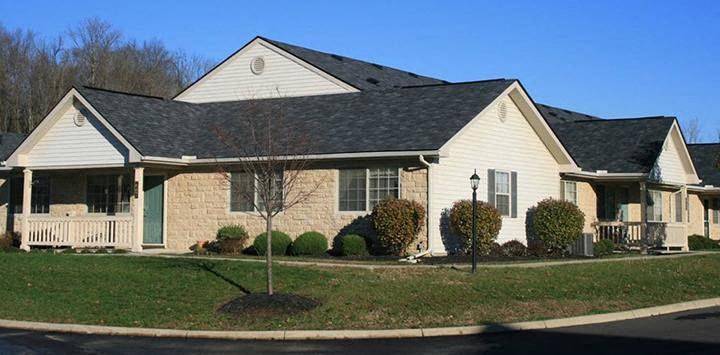 a white house with a black roof on a street