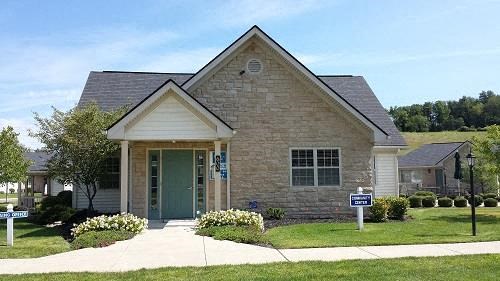 a small brick house with a green door