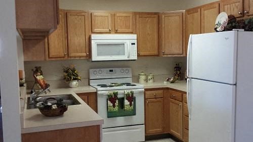 a kitchen with white appliances and wooden cabinets
