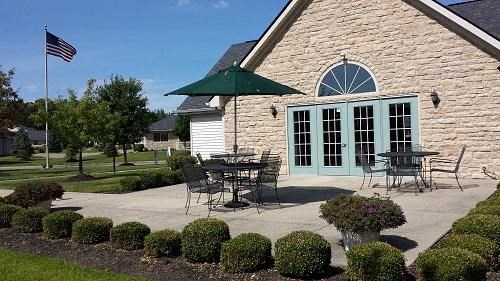 a patio with tables and chairs outside of a brick building
