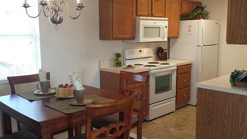 a kitchen with white appliances and a table