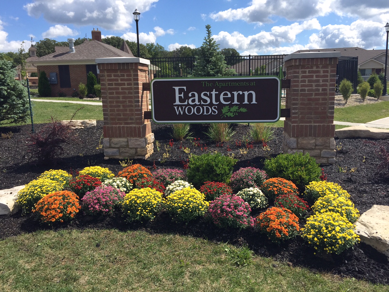 a sign for eastern woods in front of a garden of flowers