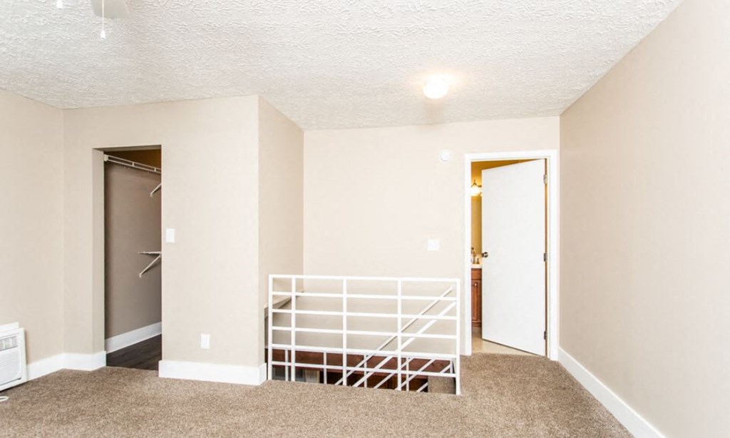 an empty living room with a white crib and a closet