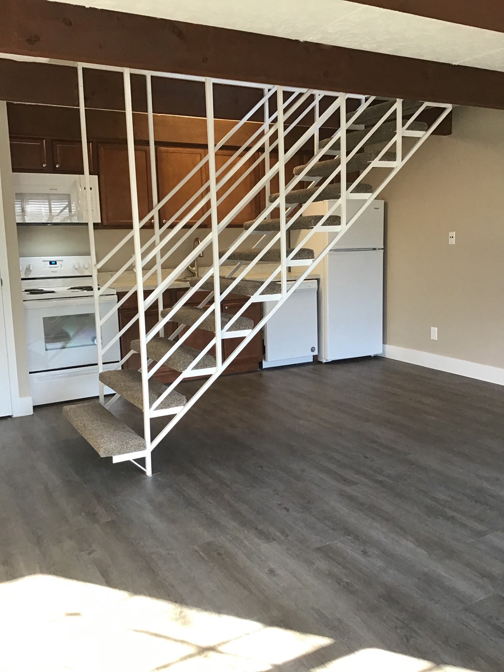 a white spiraled staircase in a living room with wood floors