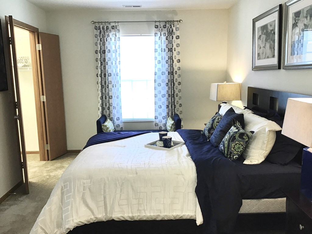 a bedroom with a bed and a window with curtains