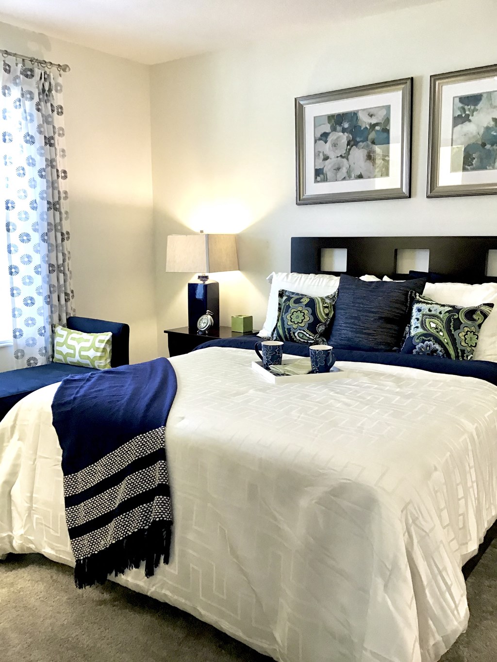 bedroom with two beds with blue and white bedding and framed pictures on the wall