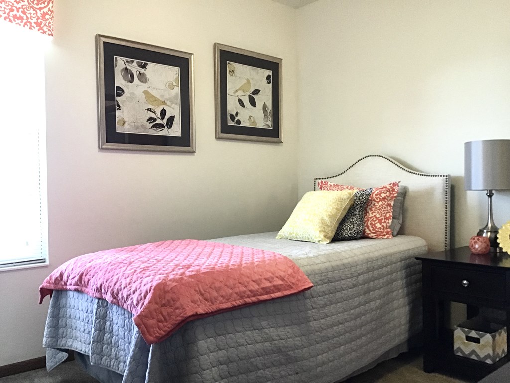 a bedroom with a bed and two pictures on the wall