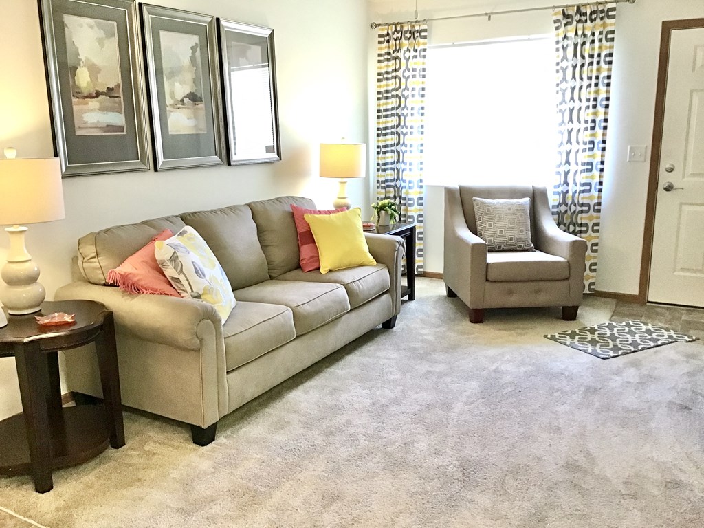 a living room with couches and chairs and a window