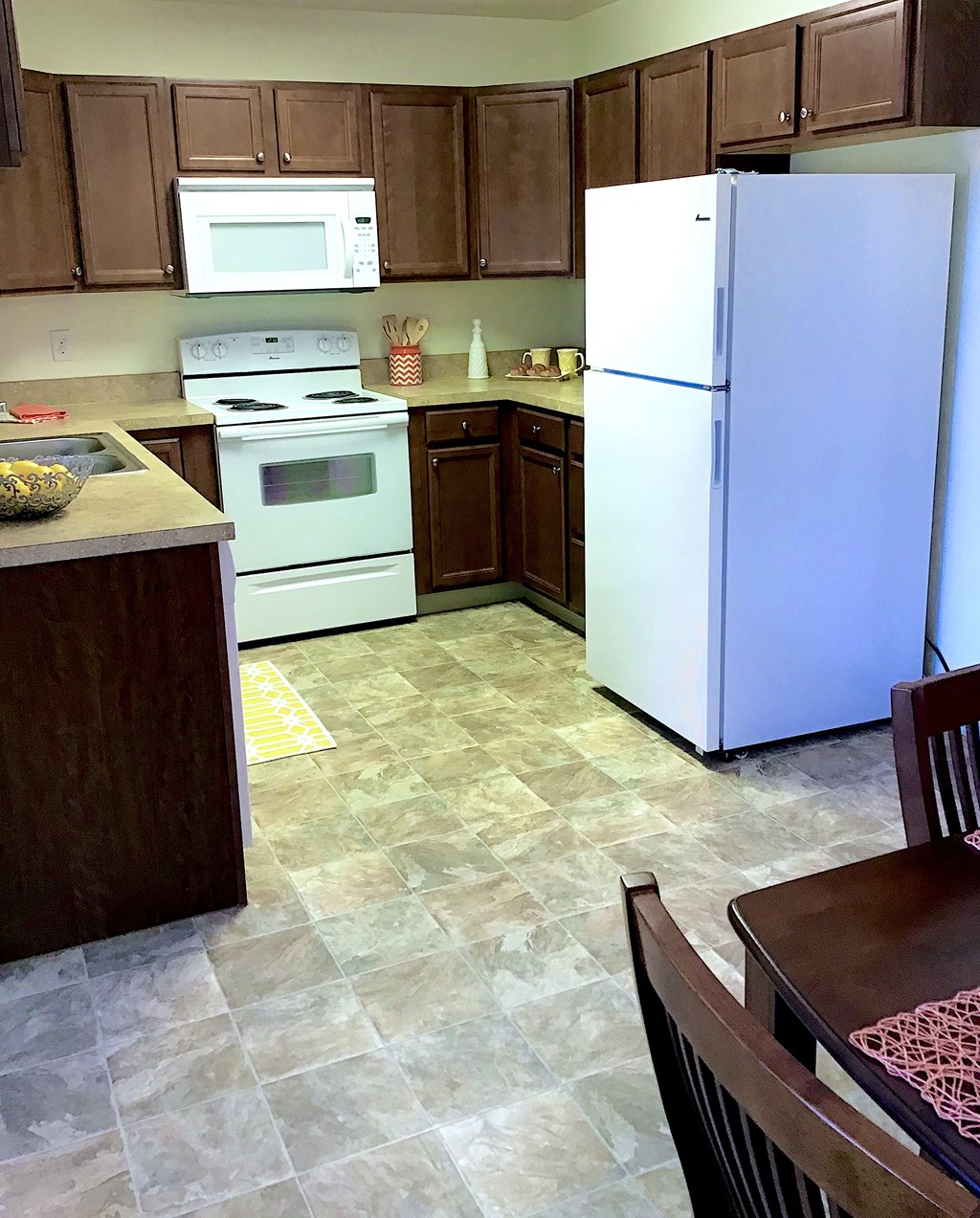 a kitchen with white appliances and brown cabinets