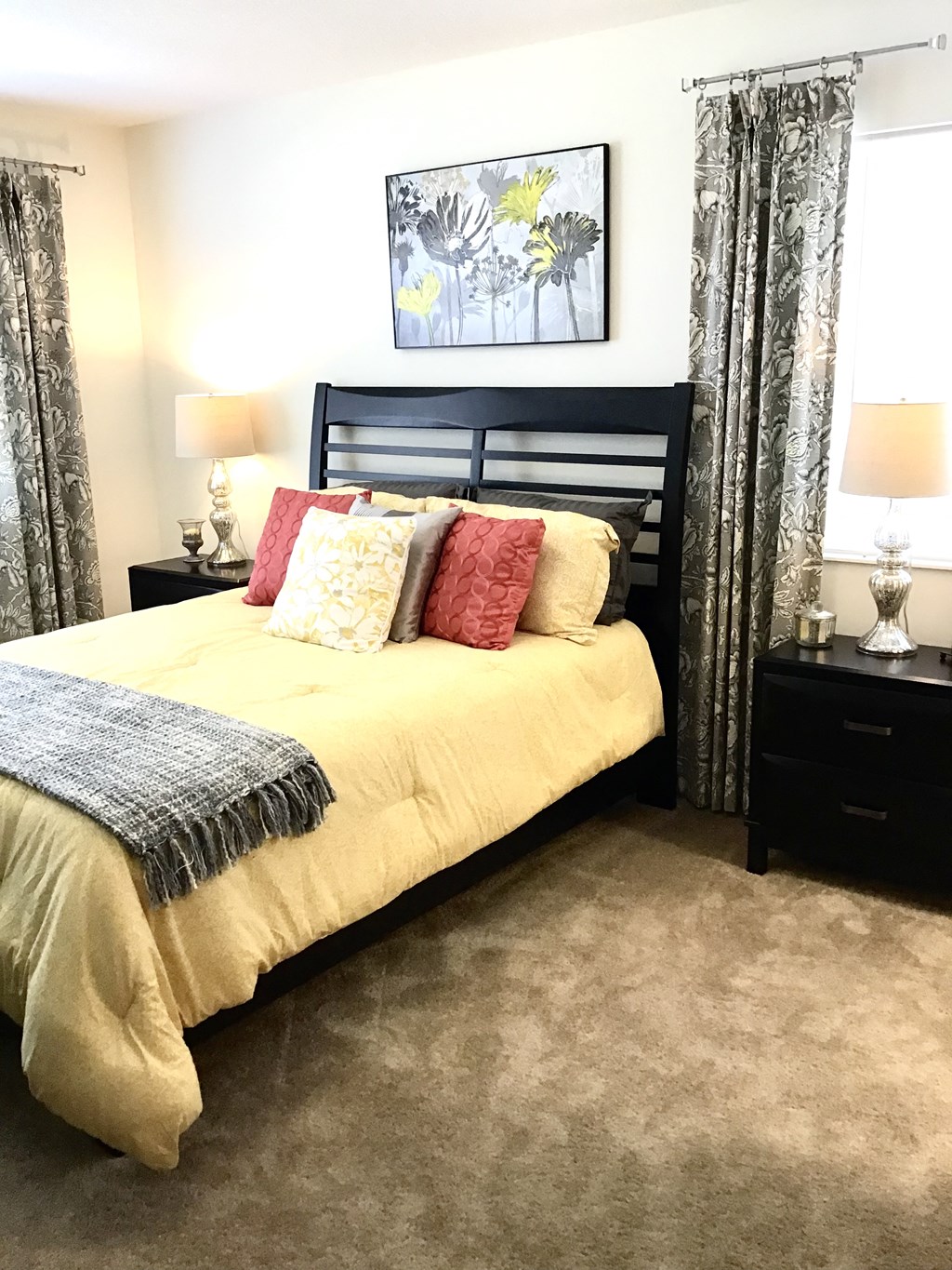 a bedroom with a bed with pillows and curtains