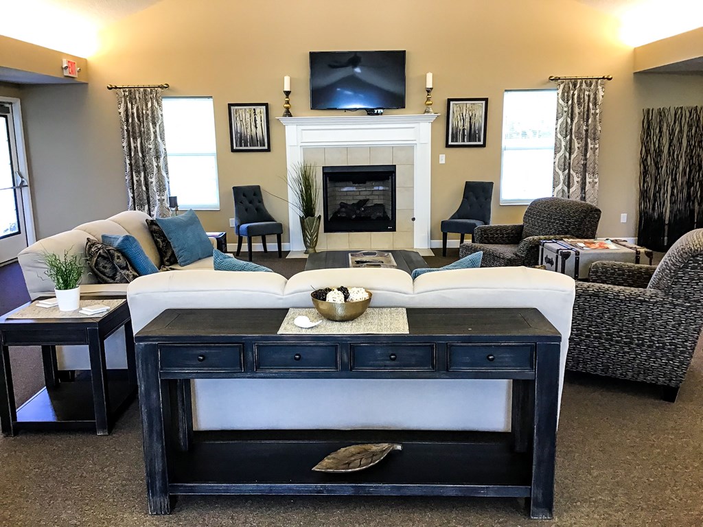 a living room with a couch and a table in front of a fireplace