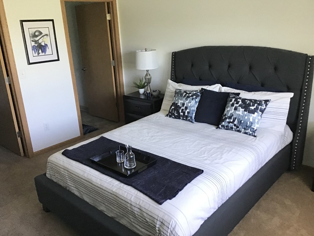 the master bedroom has a large bed with black and white sheets and pillows