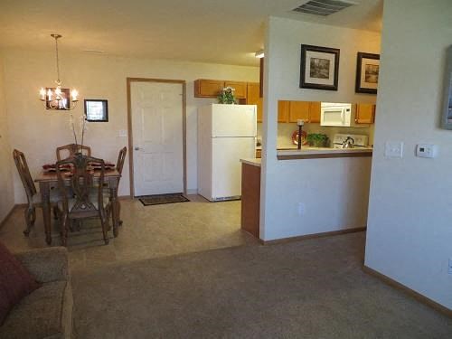 a living room and kitchen with a table and chairs