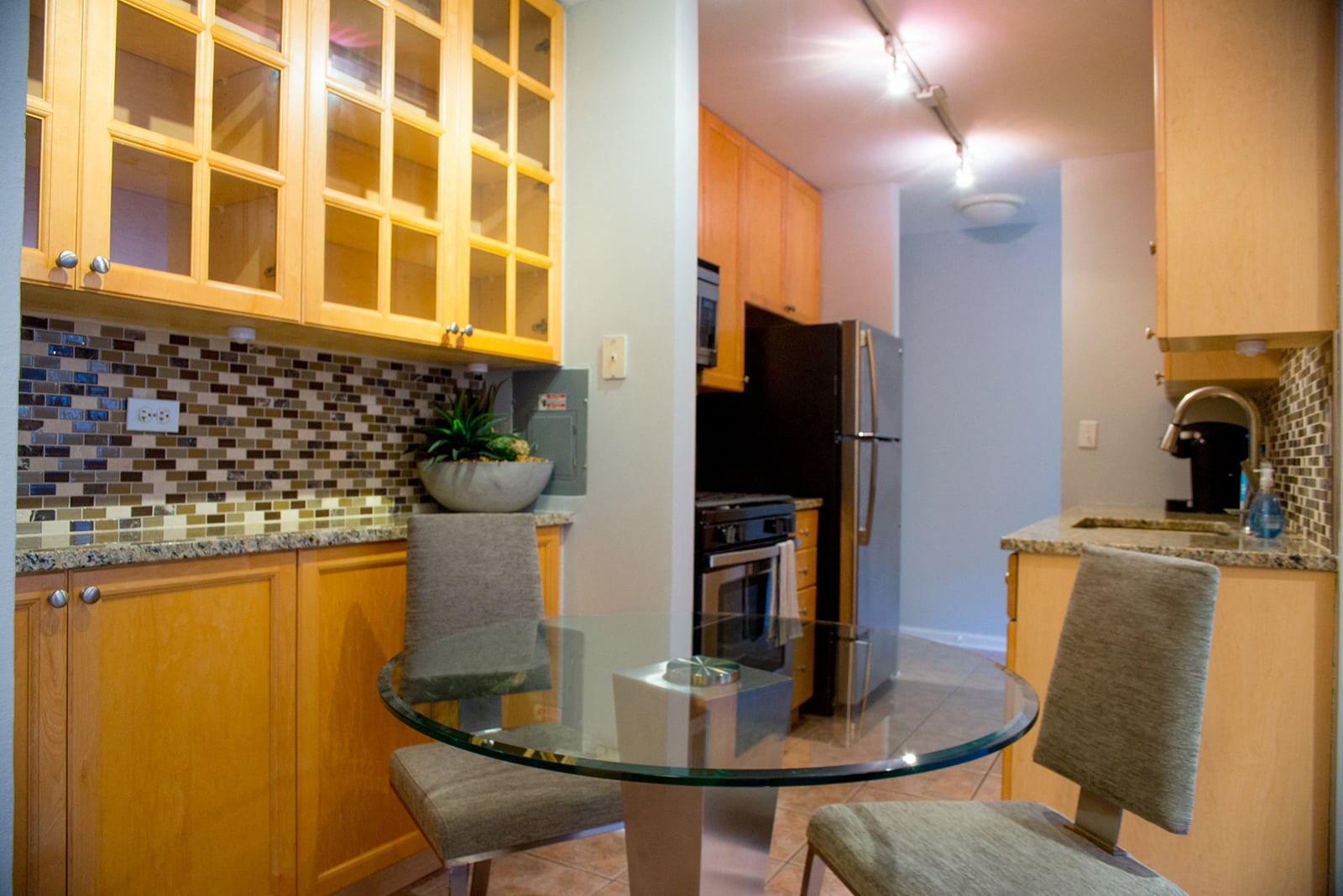 A kitchen with a glass table and chairs.
