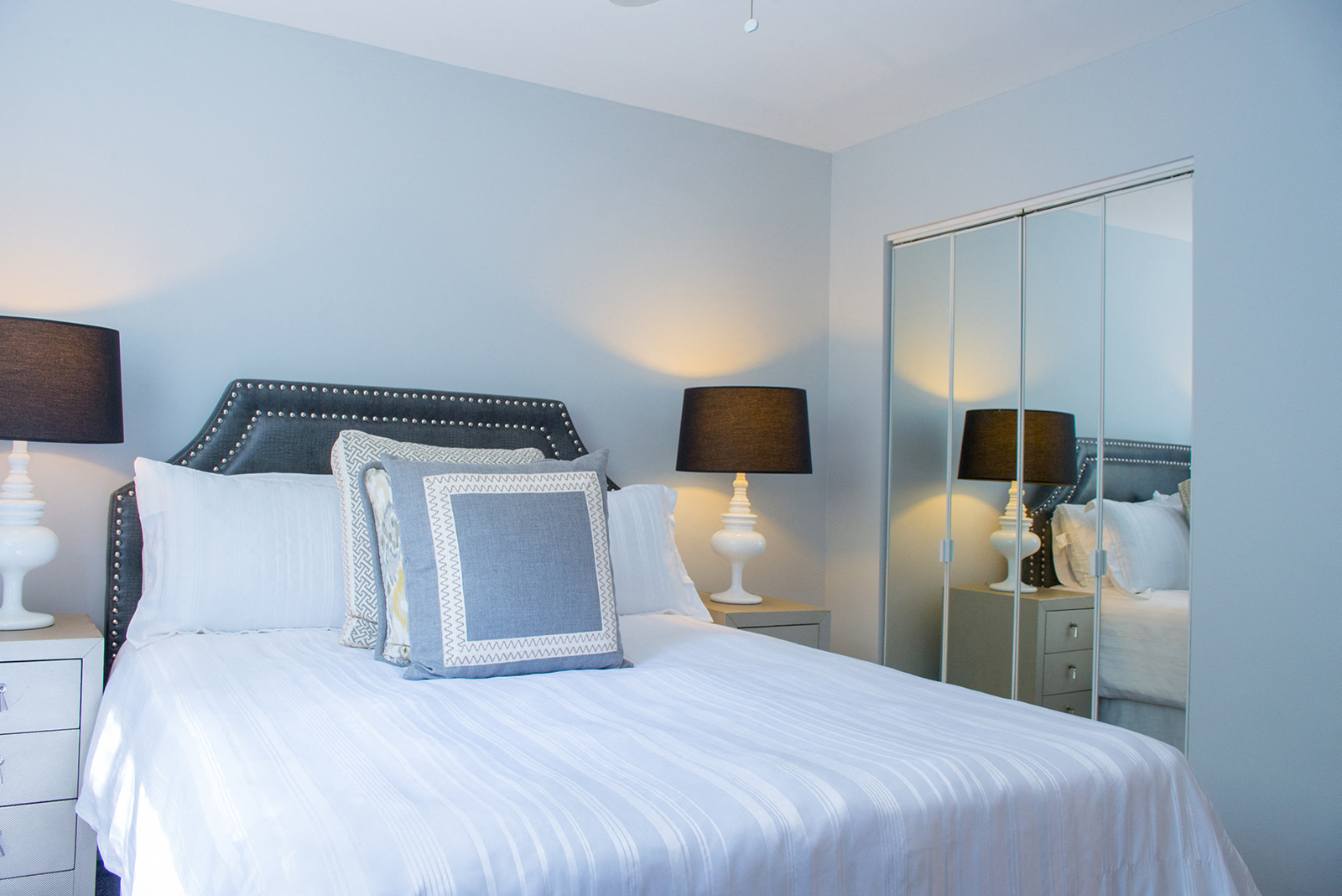 A bedroom with a bed, nightstand, and two lamps.