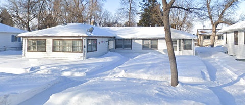 A house with a snow covered roof and driveway.