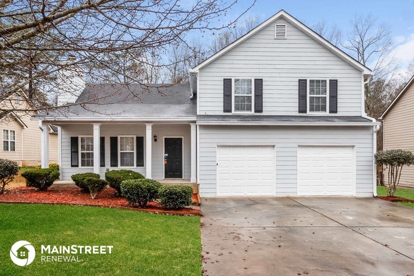 a white house with black shutters and a driveway