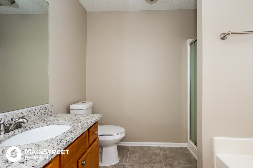 a bathroom with a toilet and a sink and a mirror