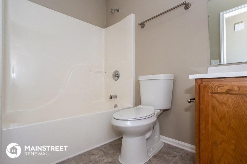 a bathroom with a toilet and a tub and a sink