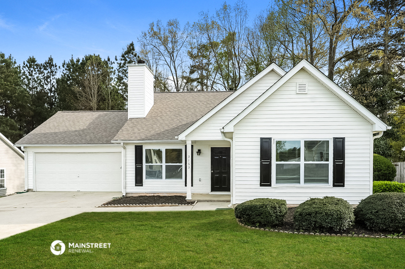 a white house with black shutters and a lawn