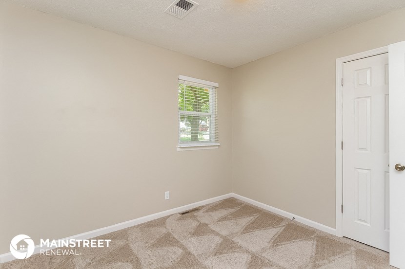 the living room of a house with a white door and a window