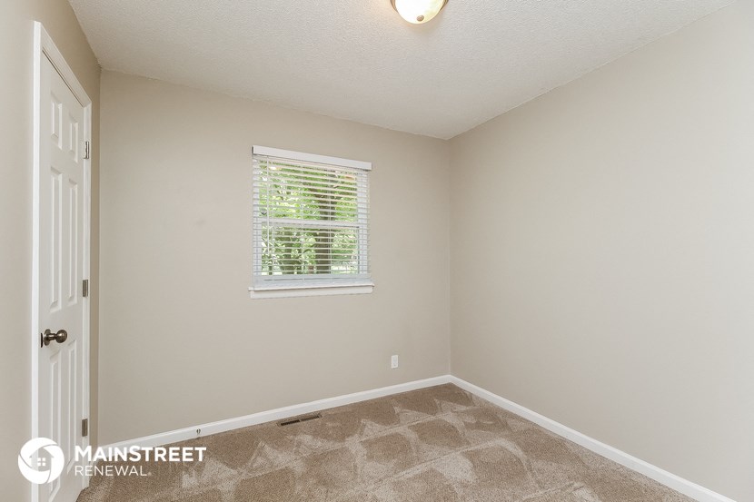 a bedroom with a window and a white door