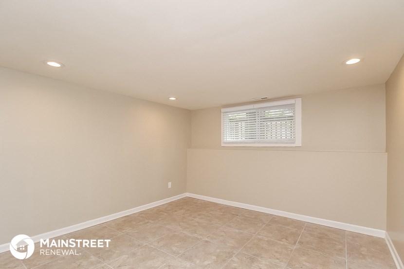 the attic of a house with a tiled floor and a window
