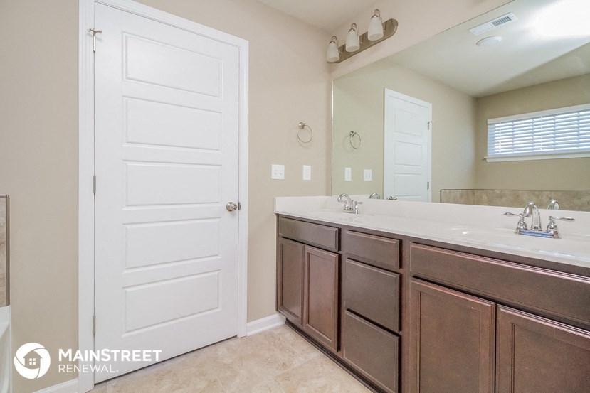a bathroom with two sinks and a mirror and a white door
