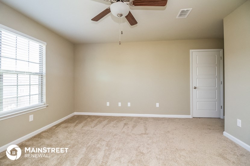 the master bedroom is spacious and has a ceiling fan